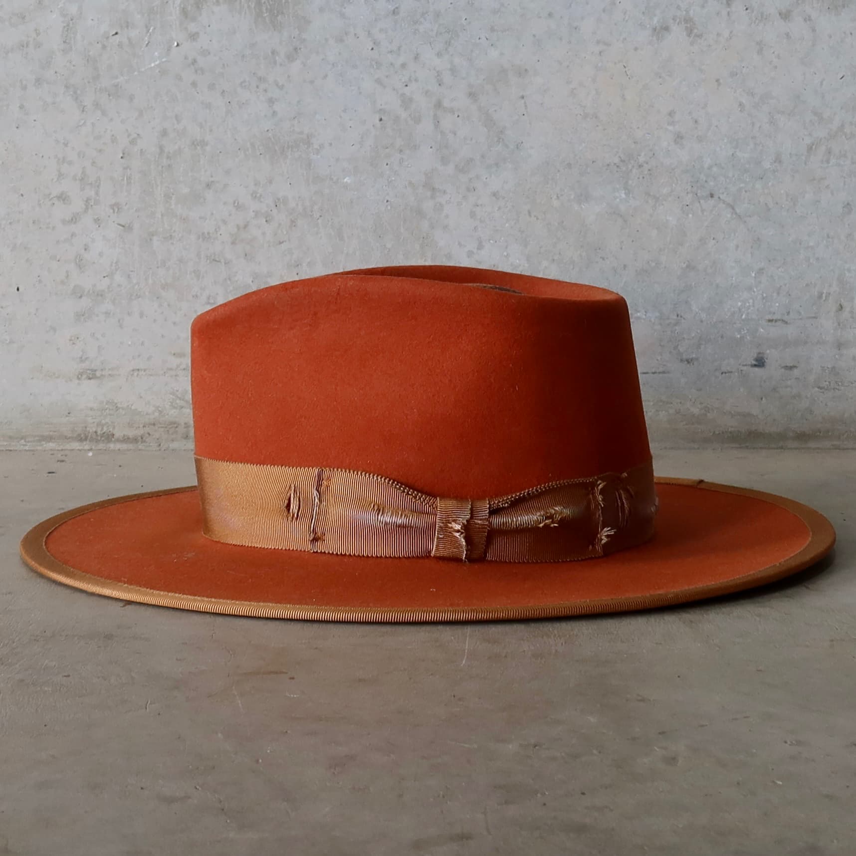 Left side view of the Karratha Spiced Pumpkin distressed felt hat by PHYLLi Designs with copper Japanese grosgrain brim trim.