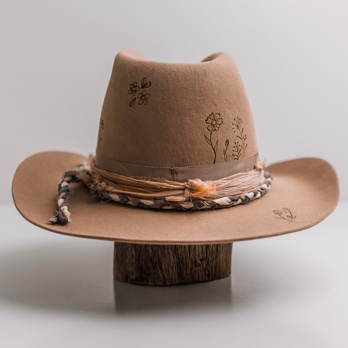 Back view of the camel felt cowboy hat La Fleurs by PHYLLi Designs featuring braided sari silk trim and peach sari silk wrap.