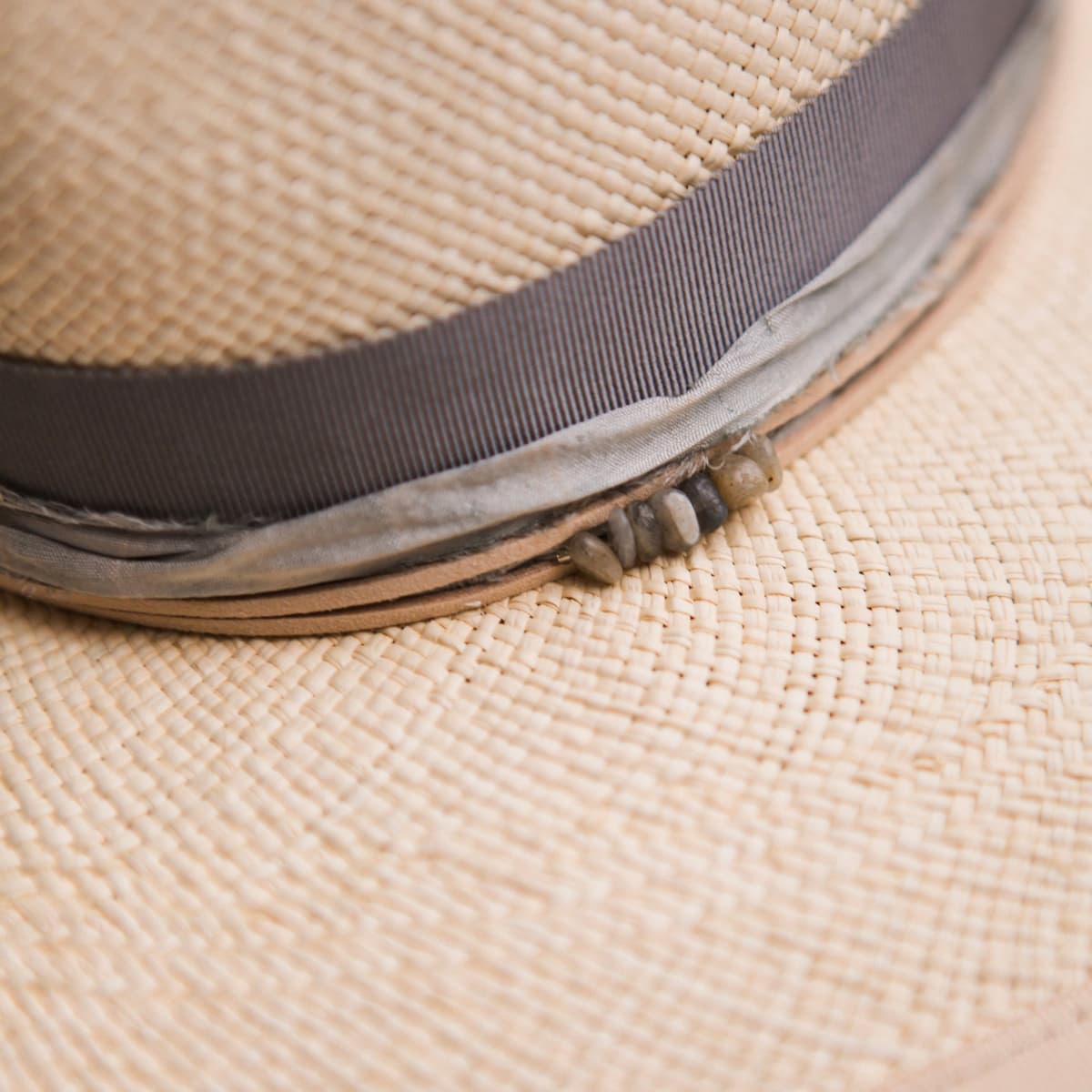 Close up detail of the La Journee Panama hat showing cement Japanese grosgrain band with storm sari silk trim and smokey quartz crystal cluster.