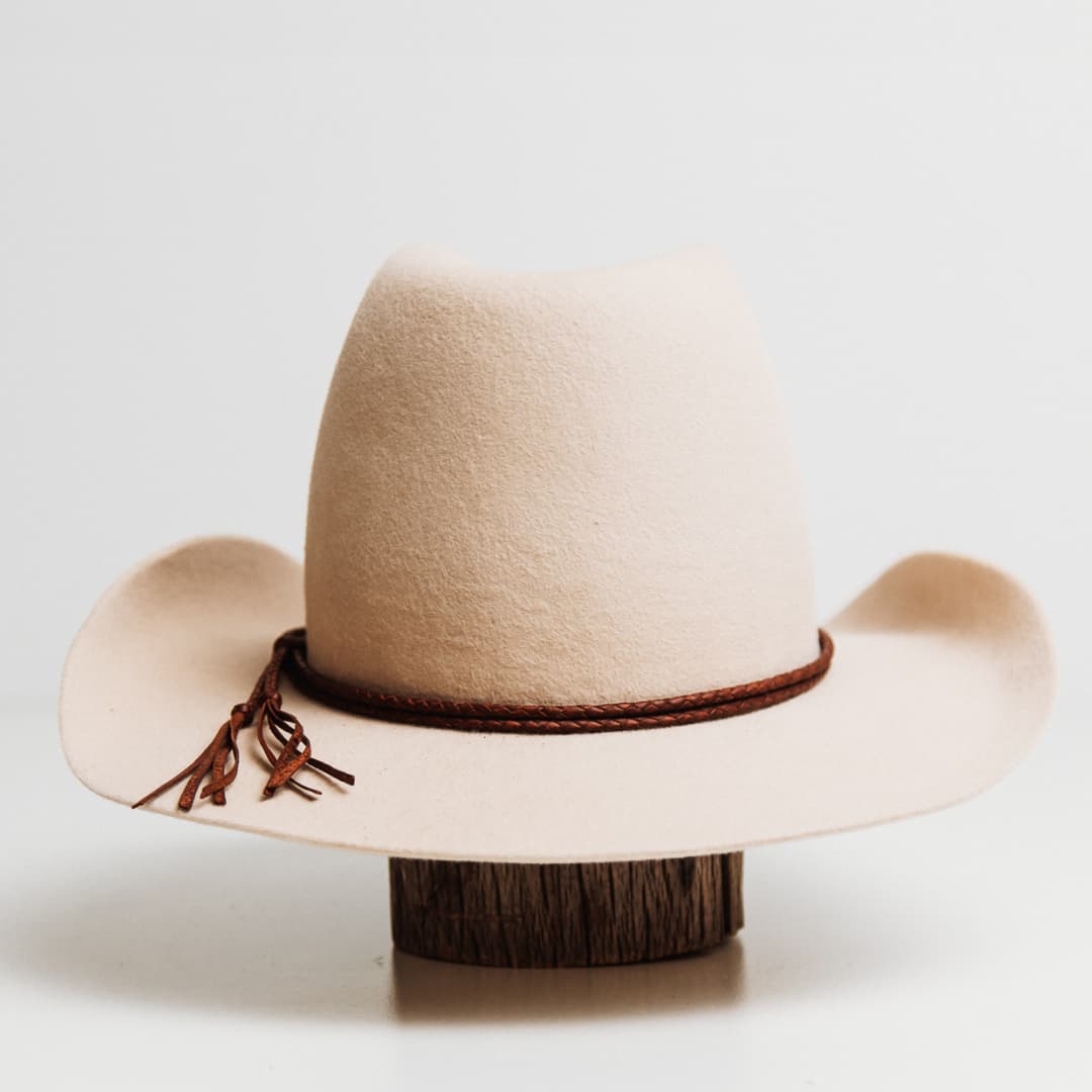 Back view of the Laurie Hat Band featuring braided kangaroo hide with tassel tie detail on a beige felt cowboy hat by PHYLLi Designs.