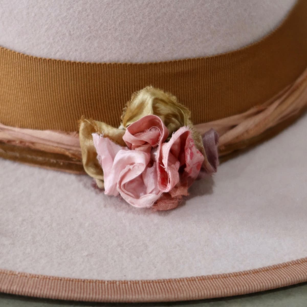 Close up detail of the Lexie felt hat showing sari silk lapel bloom with pearl centre.