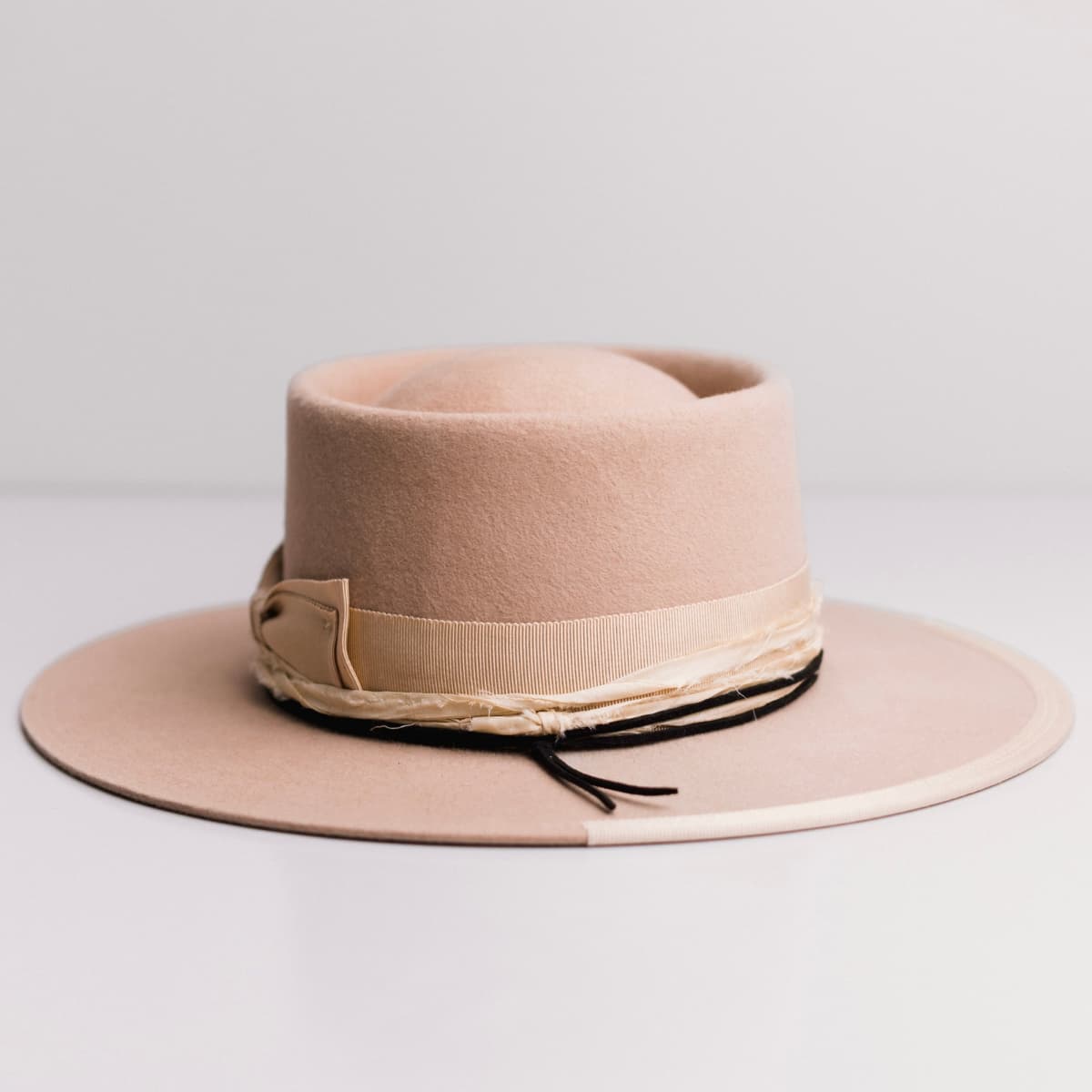 Back view of the Lover Sand felt hat by PHYLLi Designs featuring sand Japanese grosgrain band and cream sari silk trim.