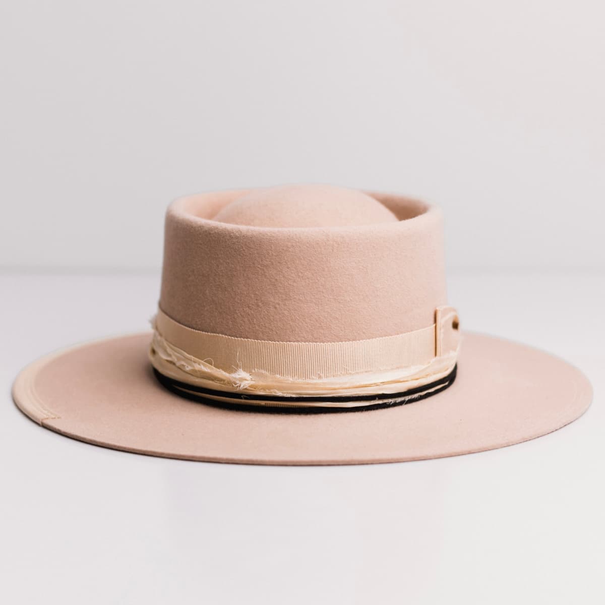 Front view of the Lover Sand felt hat by PHYLLi Designs with sand grosgrain band and cream sari silk trimming.