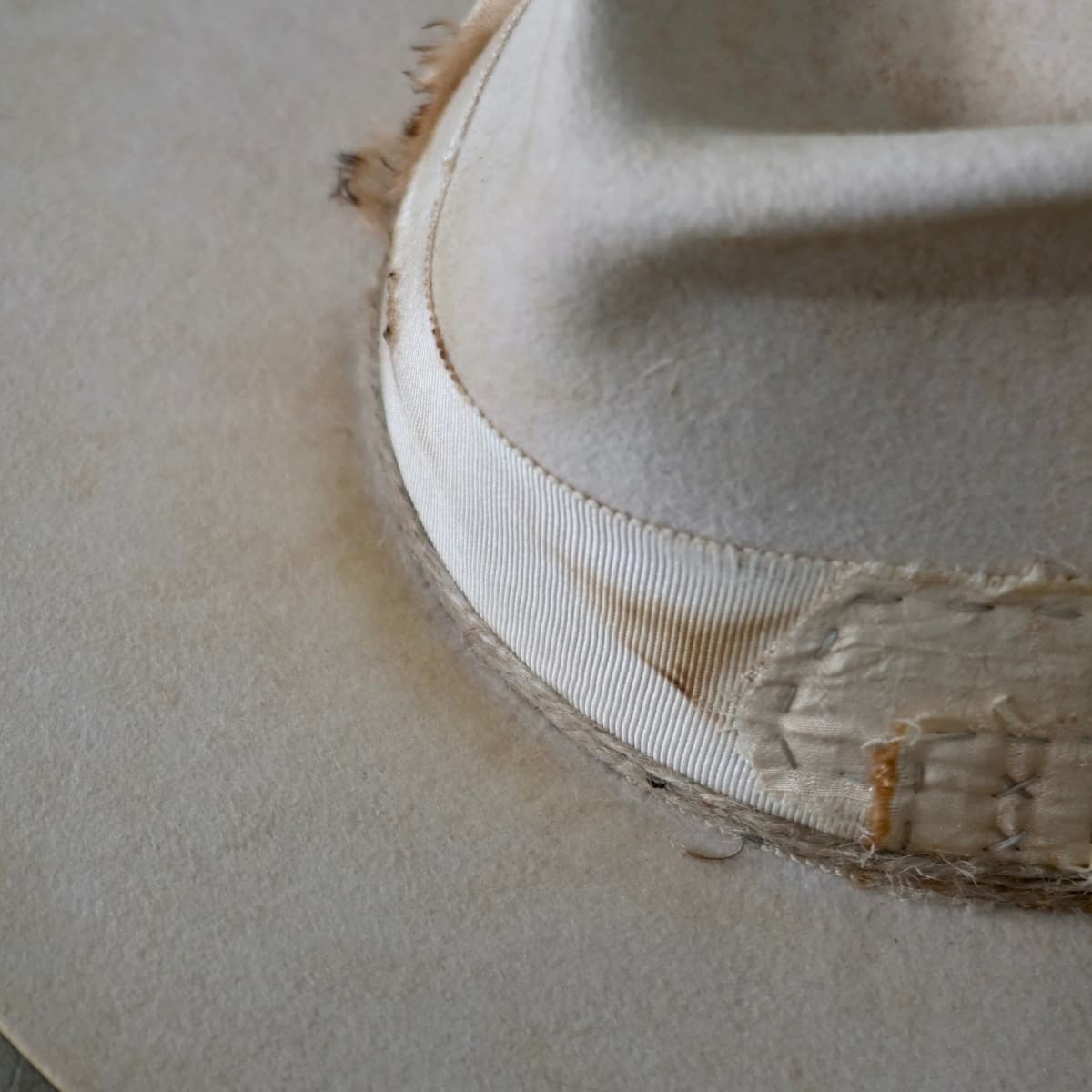 Close up detail of the Lucille Limited Edition felt hat showing distressed grosgrain band and twine wrap trims.