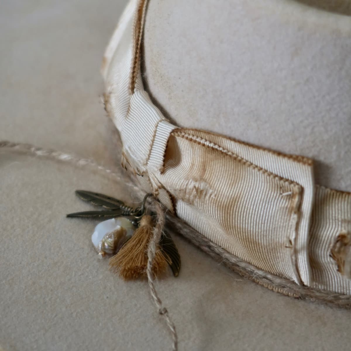 Close up detail of the Lucille Limited Edition felt hat showing distressed ivory Japanese grosgrain bow band.