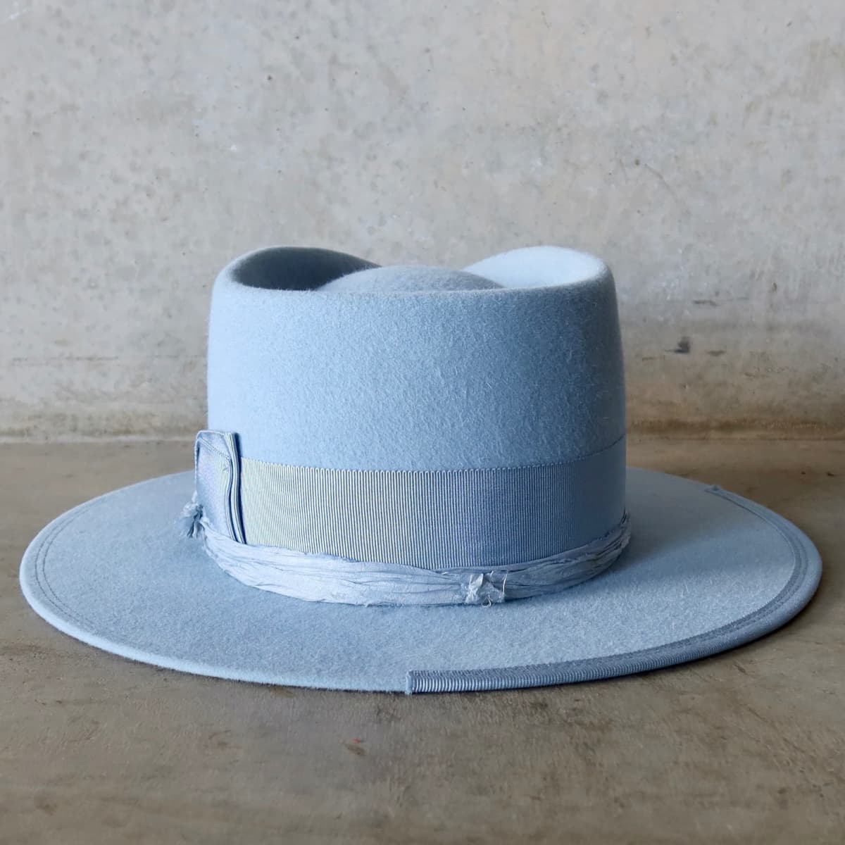 Back view of the Crystal Blue felt hat Lucinda by PHYLLi Designs featuring cornflower grosgrain double bow band.