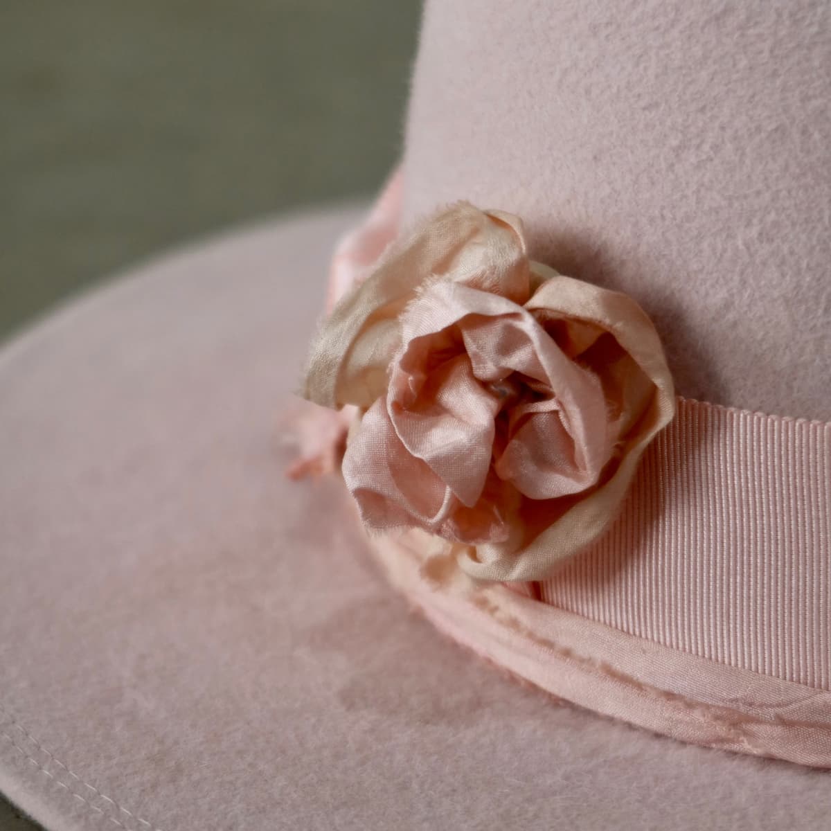 Close up detail of the Lucinda Bloom felt hat showing removable sari silk lapel bloom with pearl centre.
