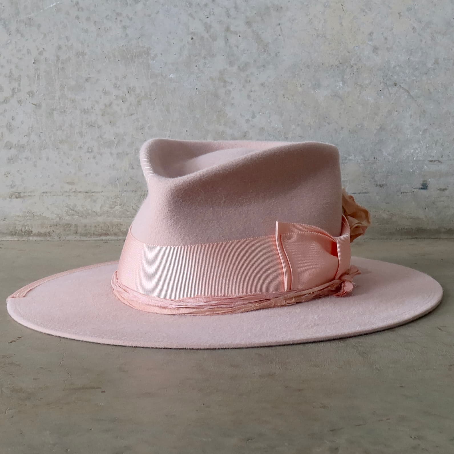 Front left angle of the Baby Pink felt hat Lucinda Bloom by PHYLLi Designs with salmon grosgrain band and tonal sari silk trim.