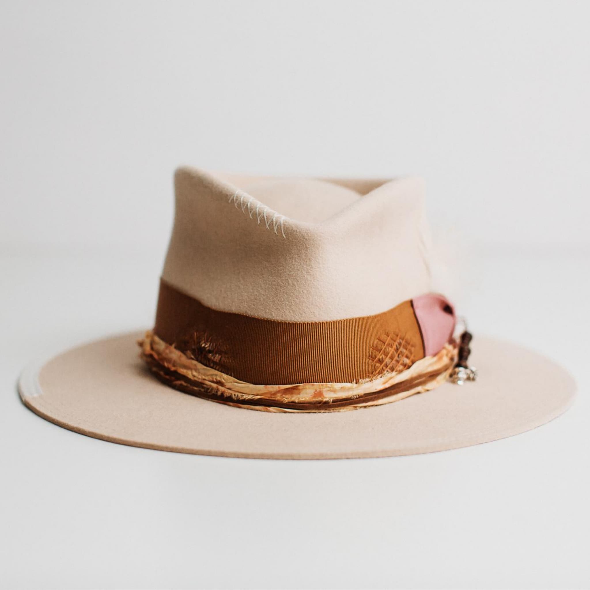 Front view of Malibu beige felt hat by PHYLLi Designs with copper grosgrain band and marigold sari silk trim.
