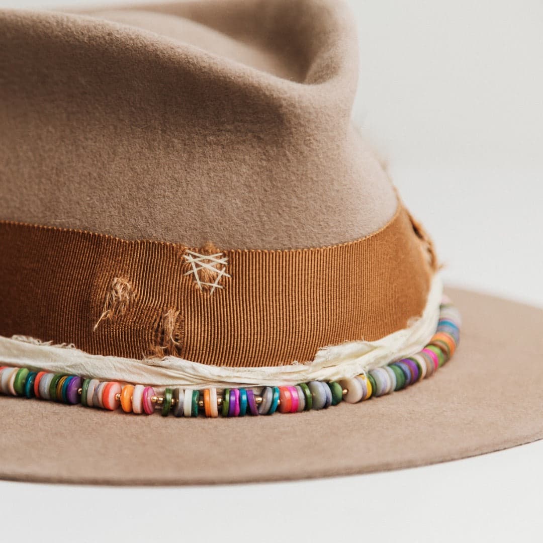 Close up detail of the Mango felt hat showing distressed copper grosgrain band with ivory darned patches.