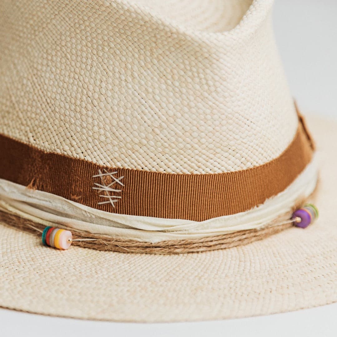 Close up detail of the Mango Panama hat showing distressed copper grosgrain band with ivory cross-stitch darning.