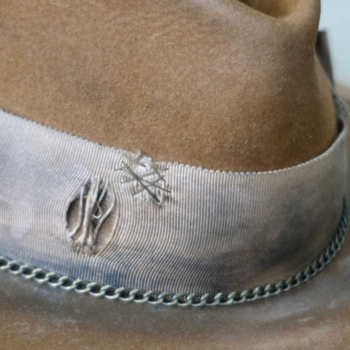 Close up detail of the Marlboro felt hat showing chocolate darned repair stitching on the distressed grosgrain band.