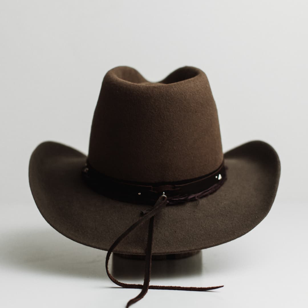 Back view of the Midnight Cowboy dirty olive felt cowboy hat by PHYLLi Designs featuring buffalo tieback studded hat band and midnight sari silk trimming.