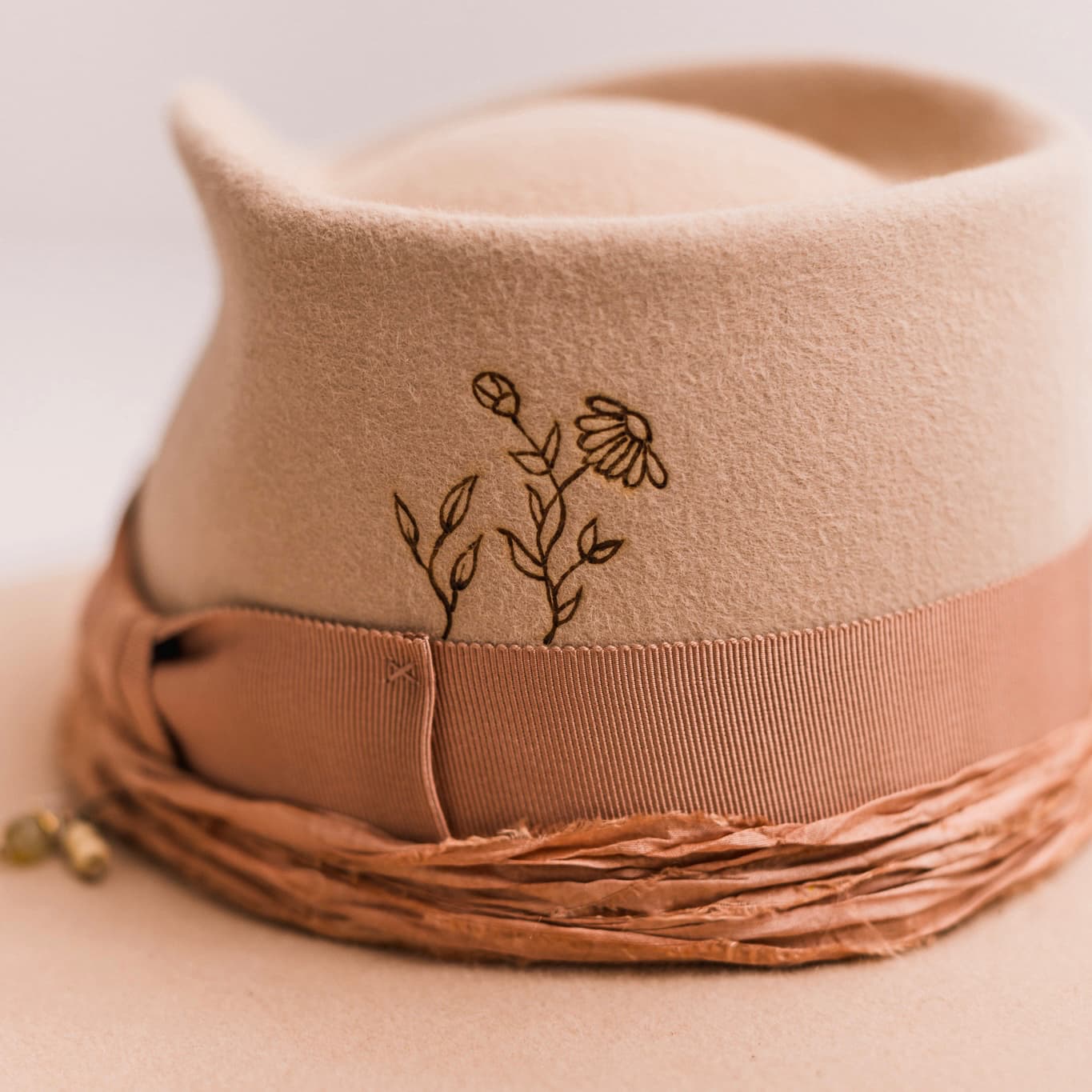 Close up detail of the Miley felt hat showing burnt branded floral crown artwork.