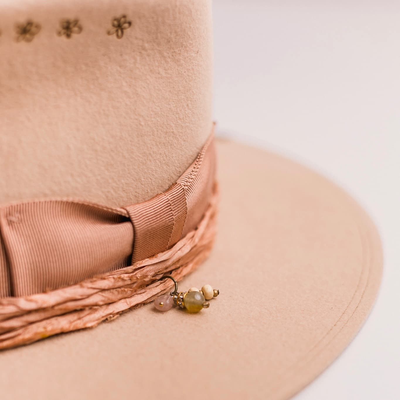 Close up detail of the Miley felt hat showing beaded charm cluster on sari silk trim.