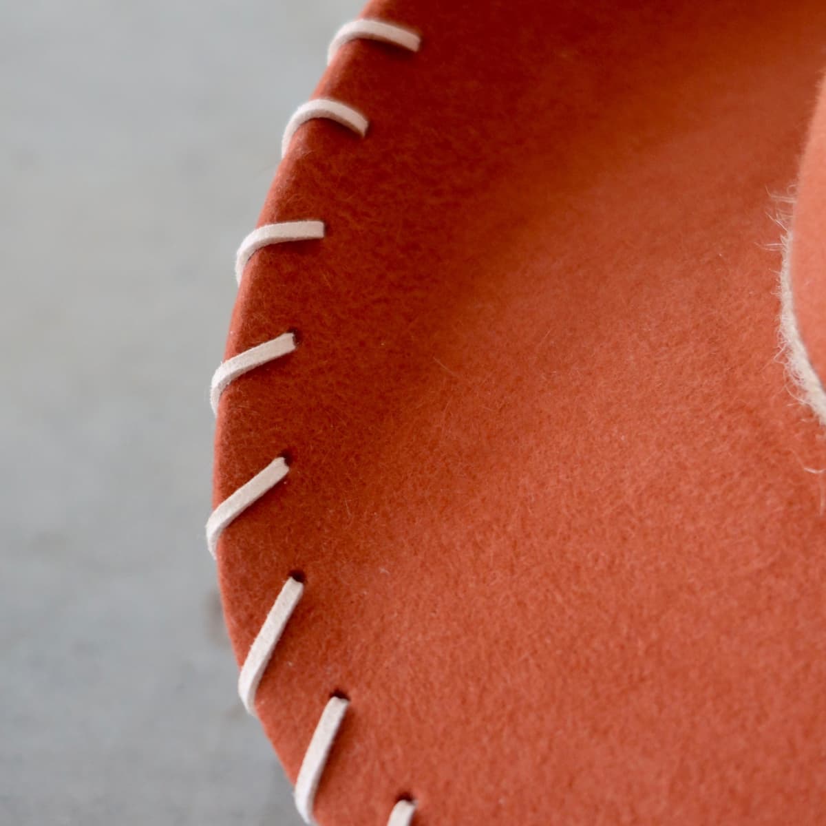 Close up detail of the Nevada cowboy hat showing nude suede brim lacing stitched through the spiced pumpkin felt brim.
