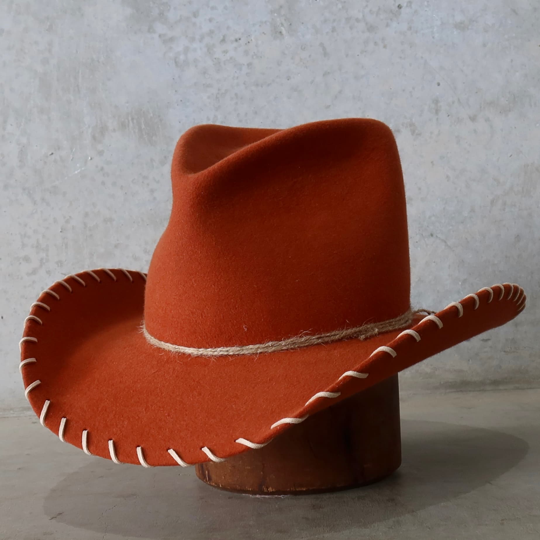 Front left angle of the spiced pumpkin cowboy hat Nevada by PHYLLi Designs with three twine wraps.