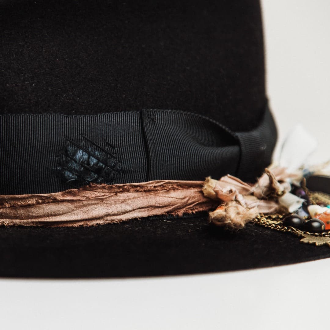 Close up detail of the Newmarket felt hat showing distressed dark navy grosgrain band with dark navy cross-stitch darning.