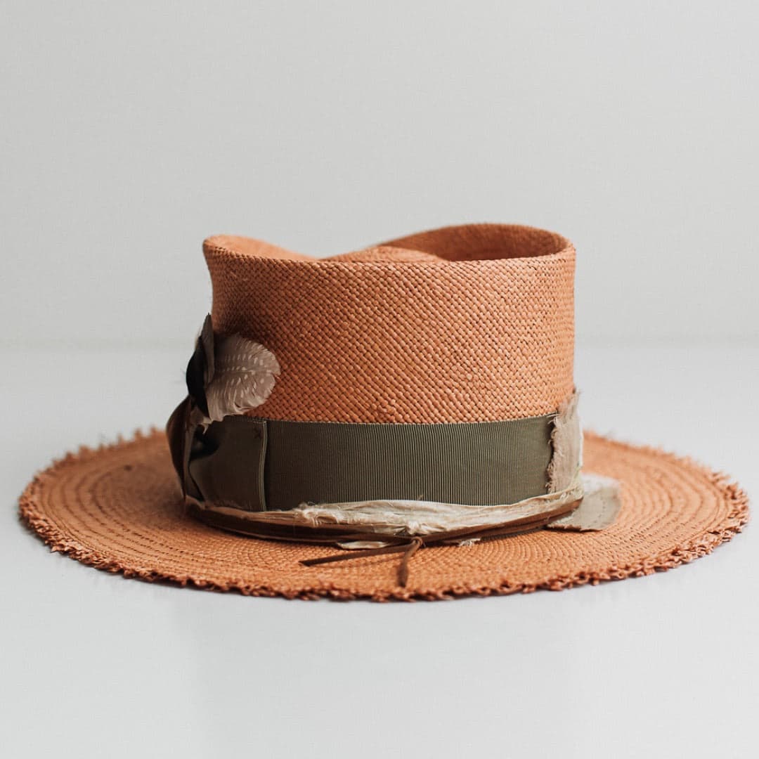 Back view of the Nim Panama biscuit Panama hat by PHYLLi Designs featuring tan suede string and sari silk trimming.