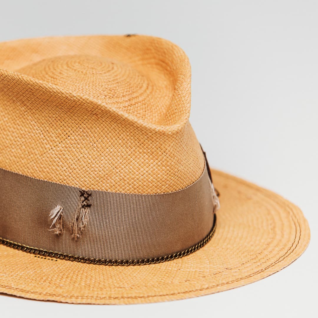 Detail of Normie Panama showing distressed taupe grosgrain band with hand-darned patches.