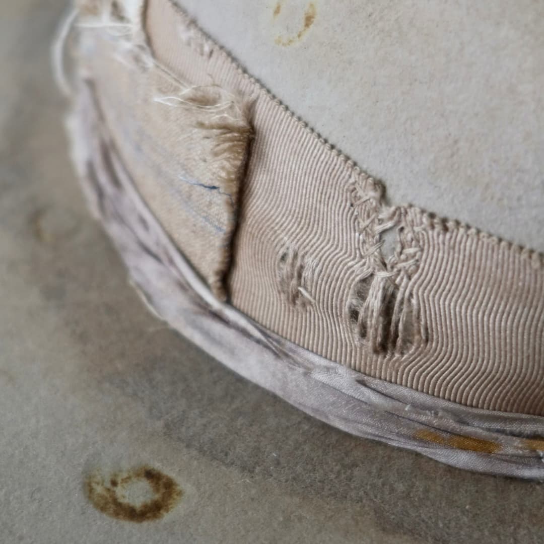 Close up detail of the Oakley Limited Edition felt hat showing distressed grosgrain band with worn stitching.