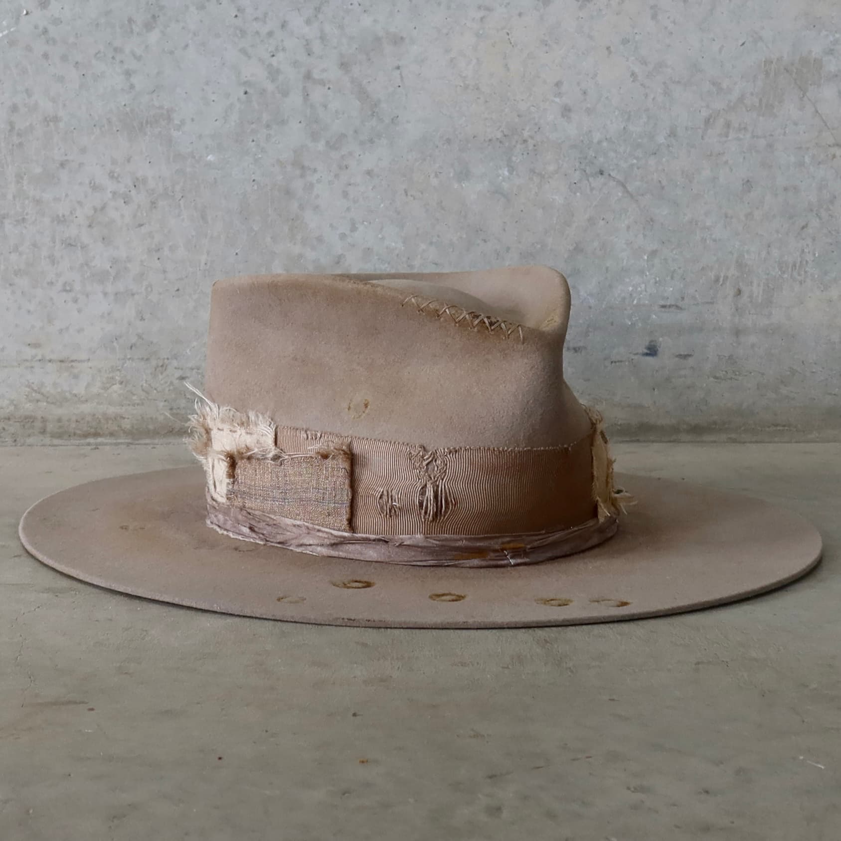 Front right angle of the Sahara felt hat Oakley Limited Edition by PHYLLi Designs with taupe hand-stitched crosses and sari silk trim.