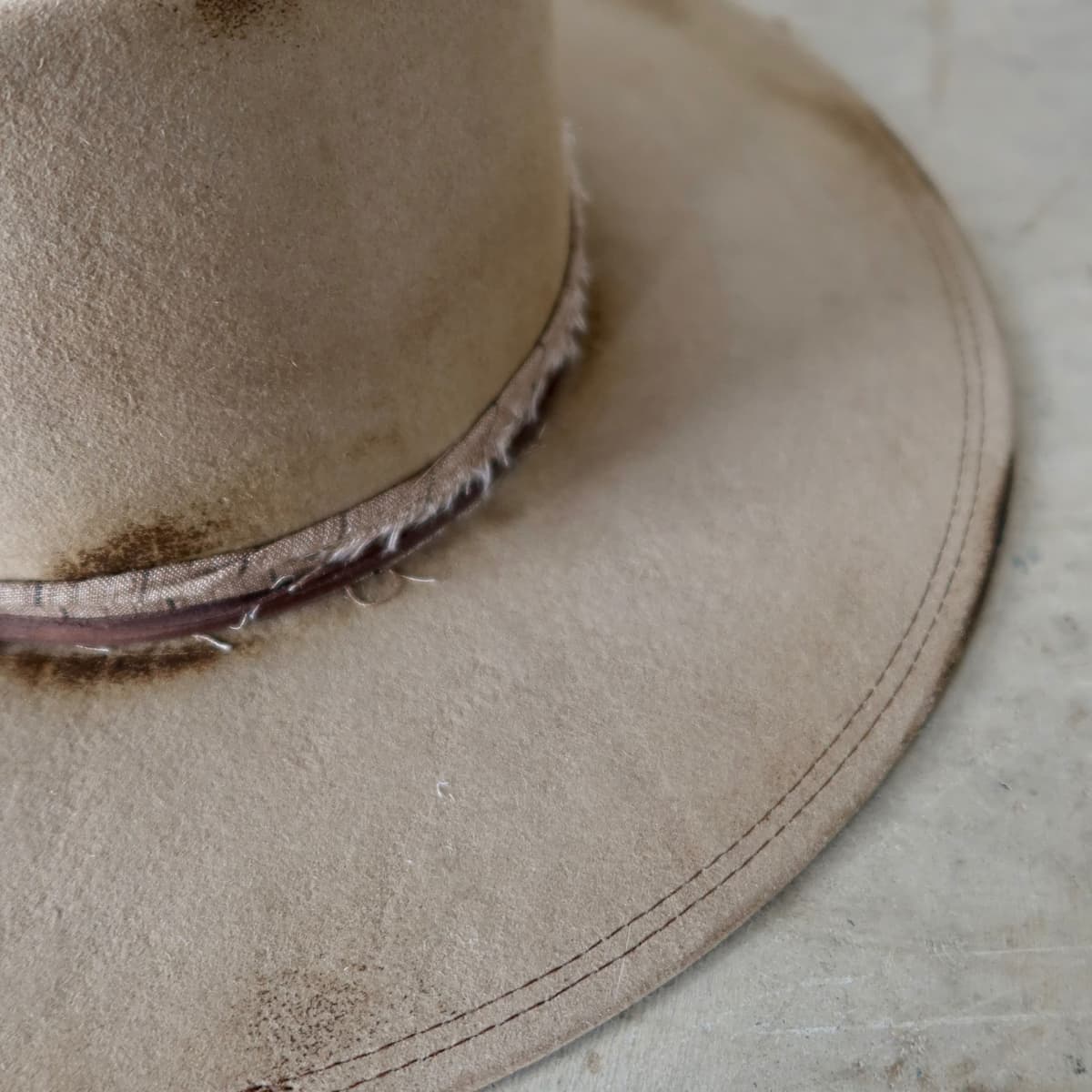 Close up detail of the Old Joe hat showing double brim stitch detail in chocolate on distressed felt.