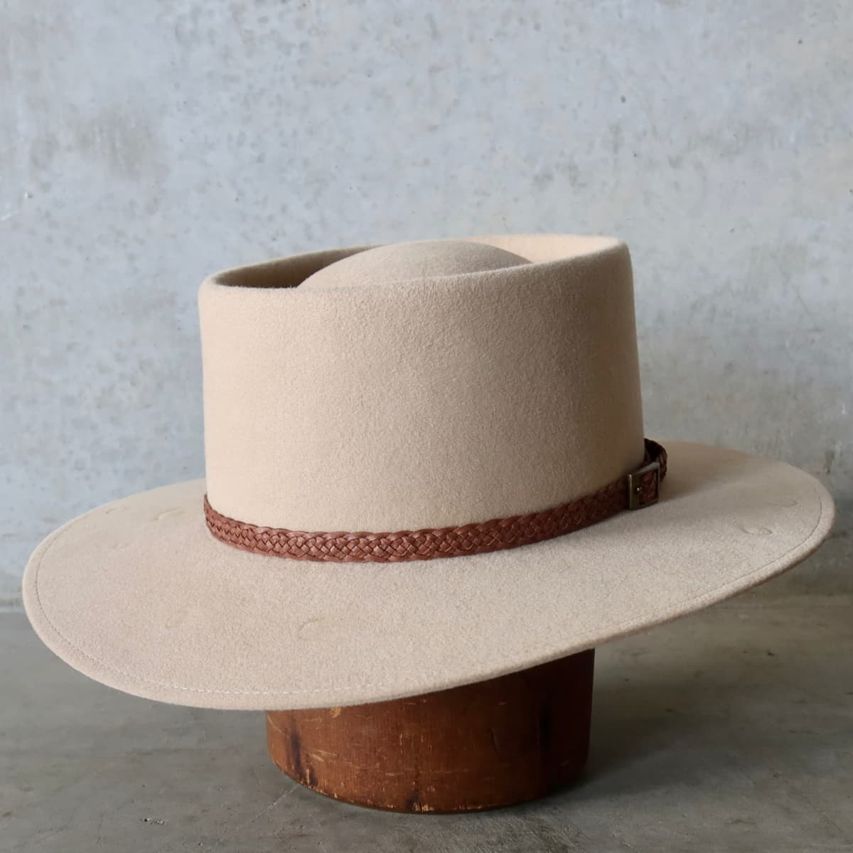 Front left angle of the Sand felt hat Paisley by PHYLLi Designs with plaited chocolate leather hat band and bronze buckle.