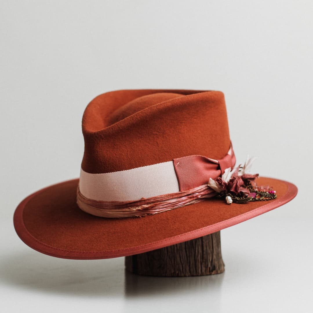 Front left angle of the Pamela spiced pumpkin felt hat by PHYLLi Designs with watermelon grosgrain bow and bronze chunky hat pin.