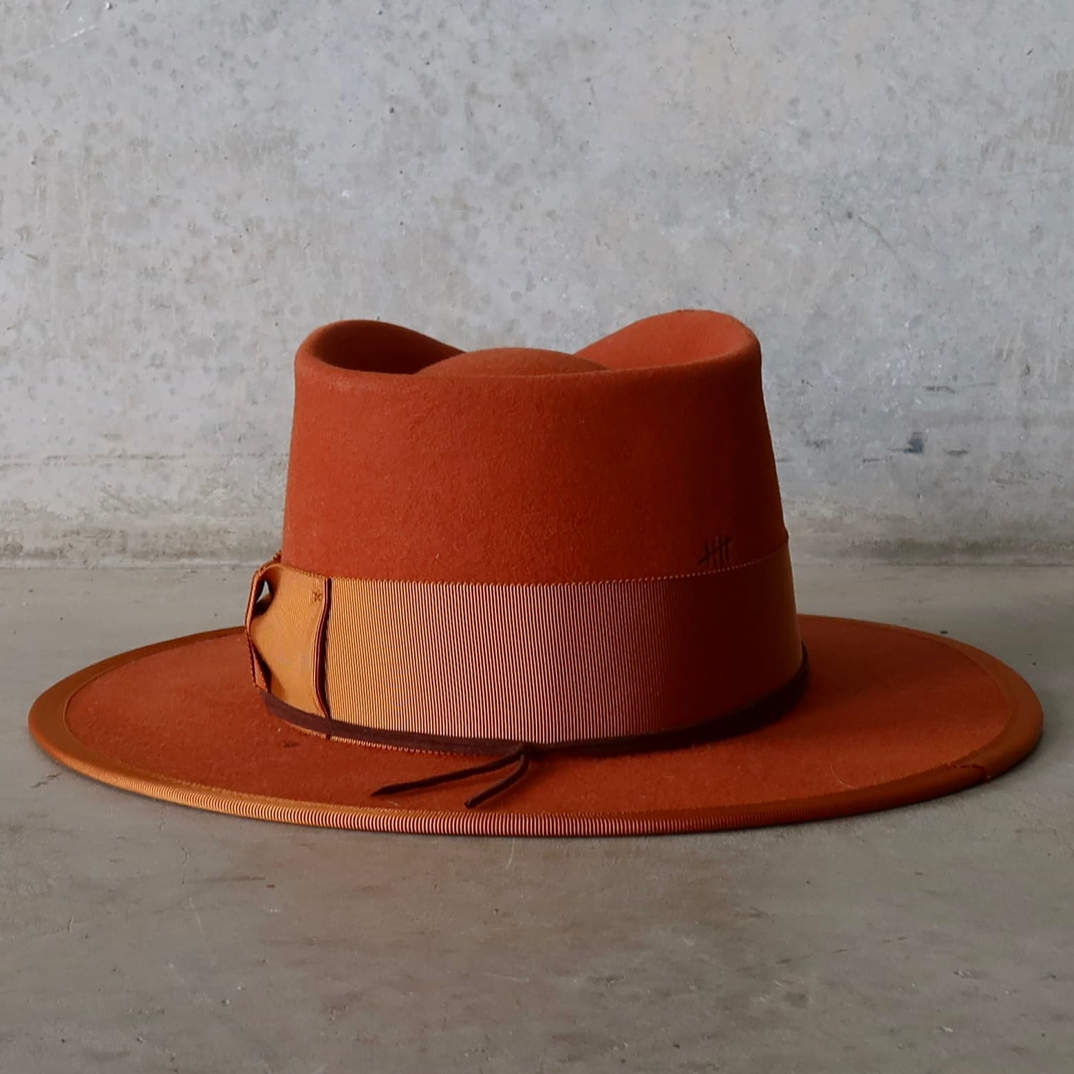 Back view of the Patrick spiced pumpkin felt hat by PHYLLi Designs featuring burnt branded crown markings.