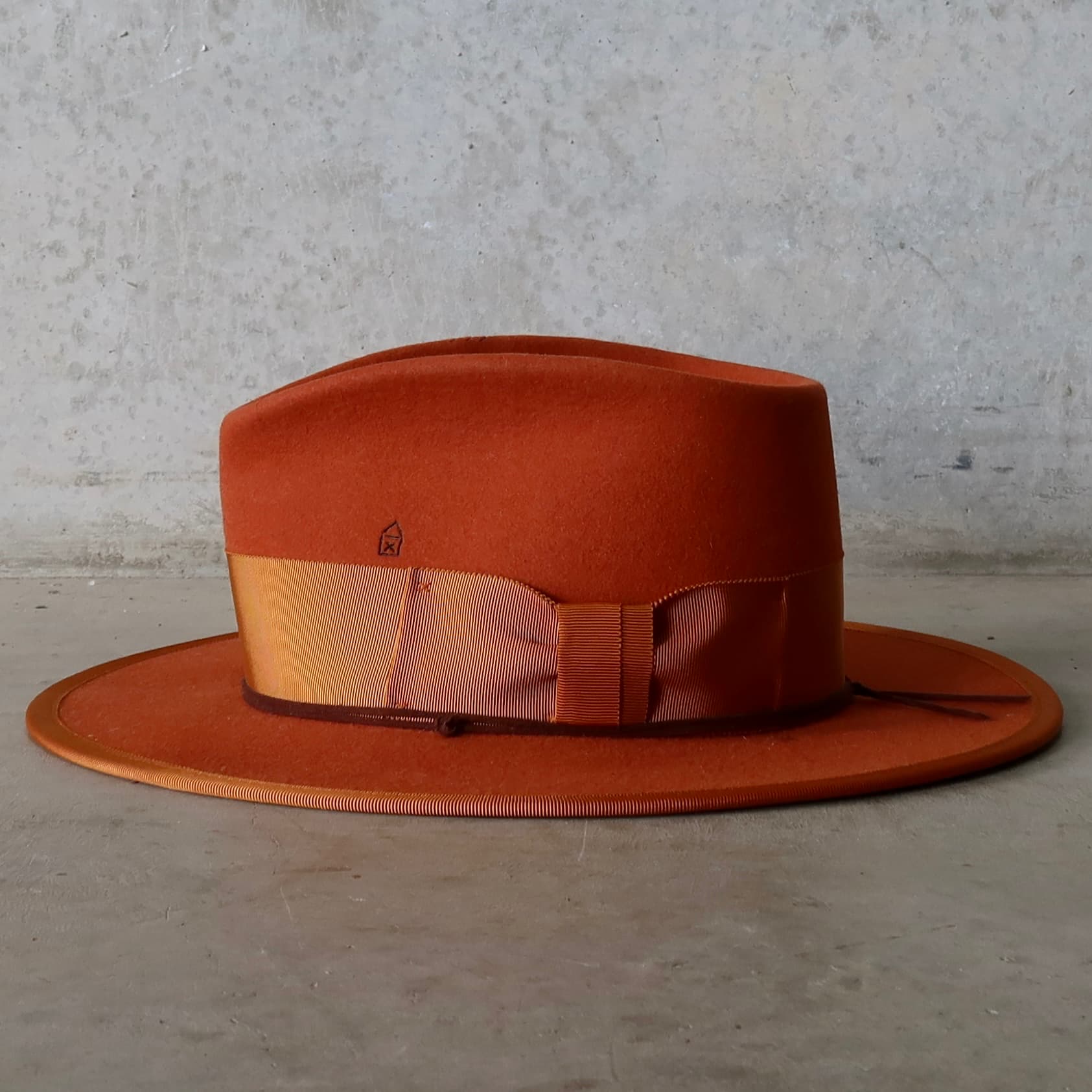 Left side view of the Patrick spiced pumpkin felt hat by PHYLLi Designs with rust grosgrain band and brim trim.