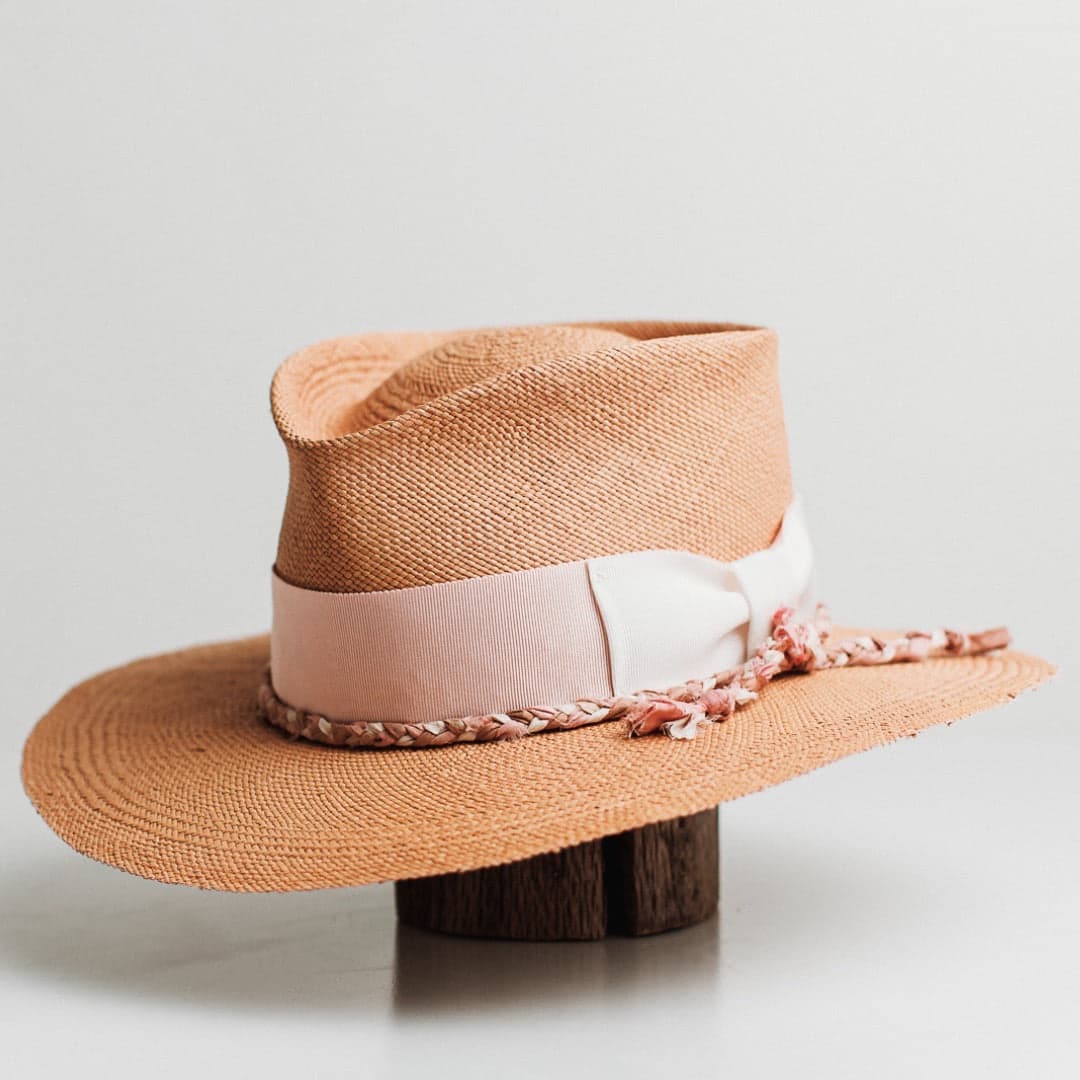 Front left angle of the Peach Panama biscuit Panama hat by PHYLLi Designs with floss pink grosgrain band and plaited sari silk trim in pink, bronze and ivory.