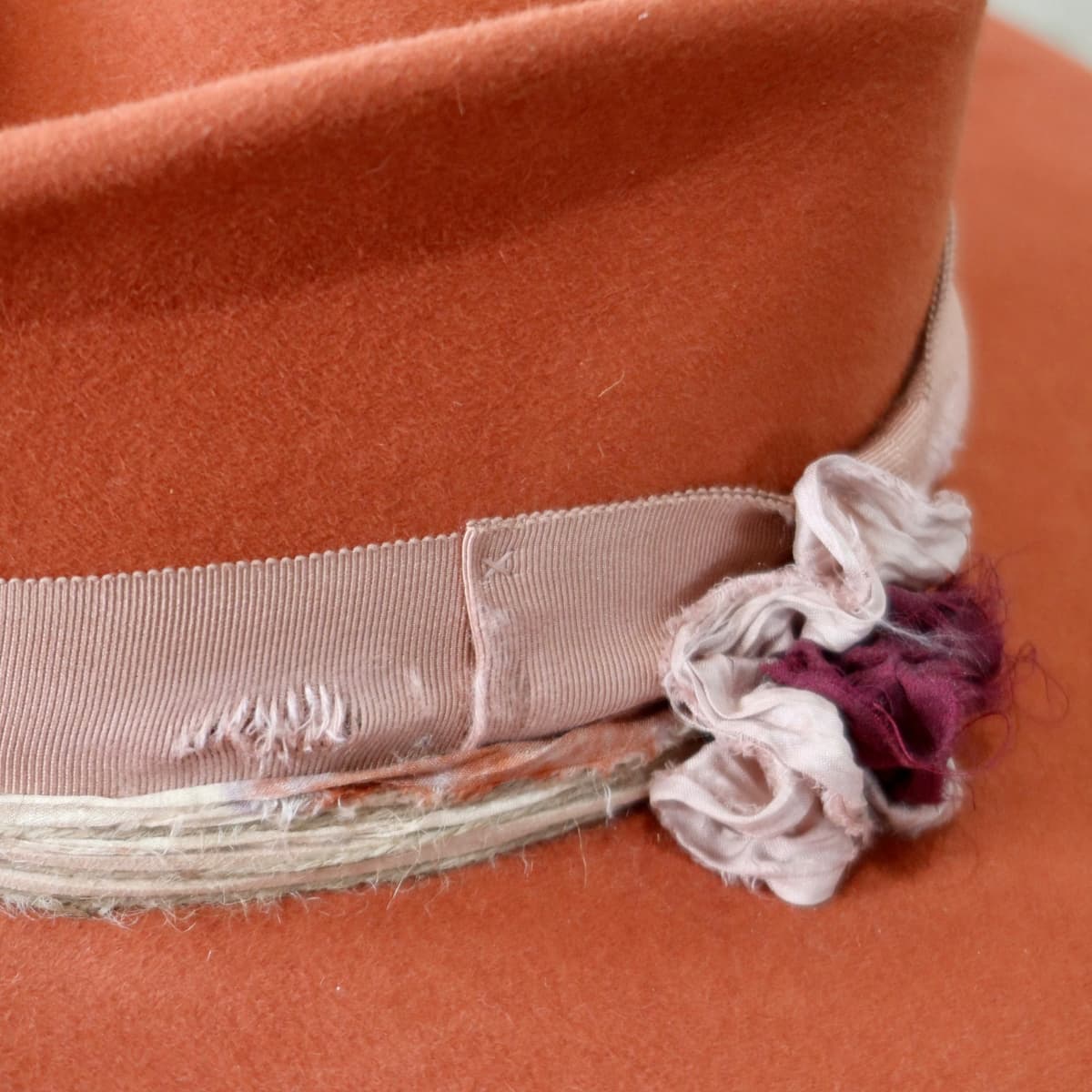 Close up detail of the Pumpkin Bloom felt hat showing layered twine wraps and sari silk trim.