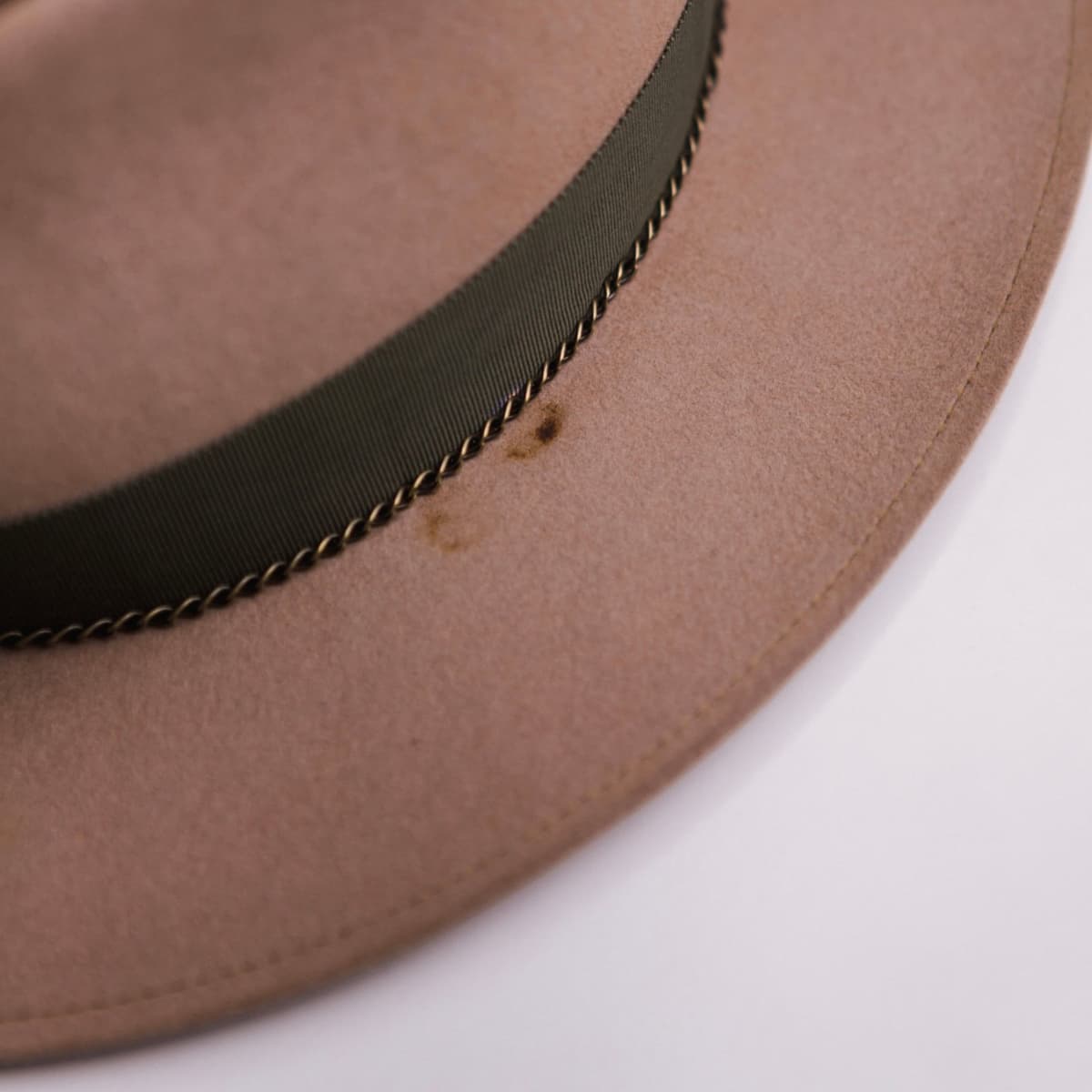 Close up detail of the Reagent felt hat showing chartreuse single brim stitch on distressed Sahara rabbit felt.