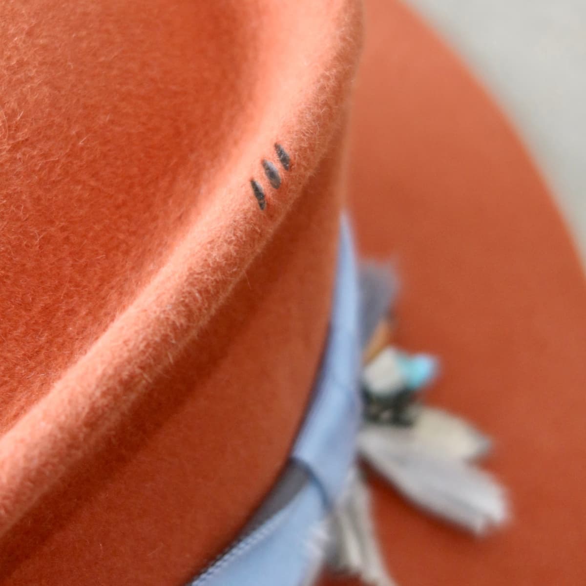 Close up detail of the Road Less Travelled felt hat showing burnt branded pattern on the crown.