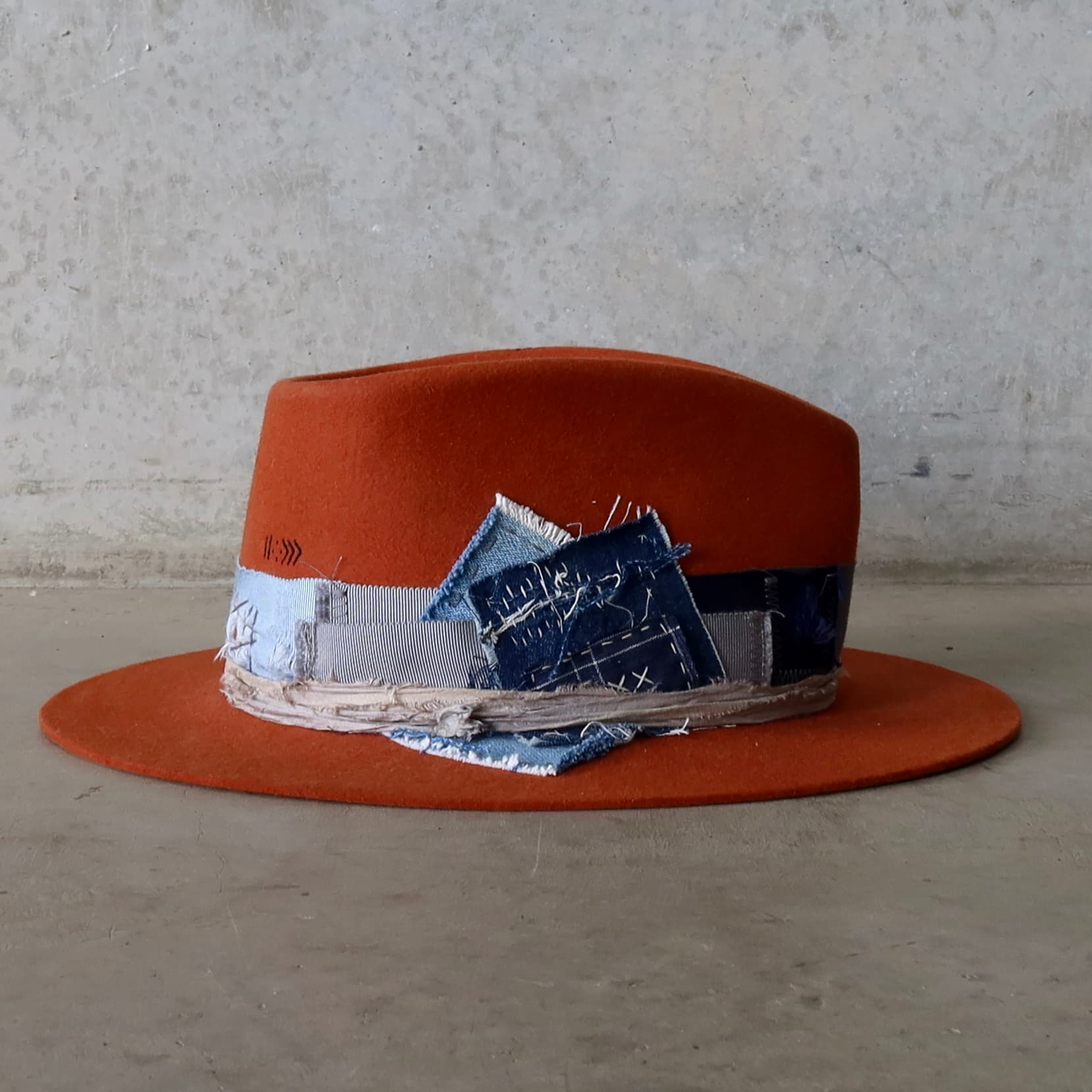 Right side view of the Road Less Travelled spiced pumpkin felt hat by PHYLLi Designs with worn denim patch and sashiko style stitching.