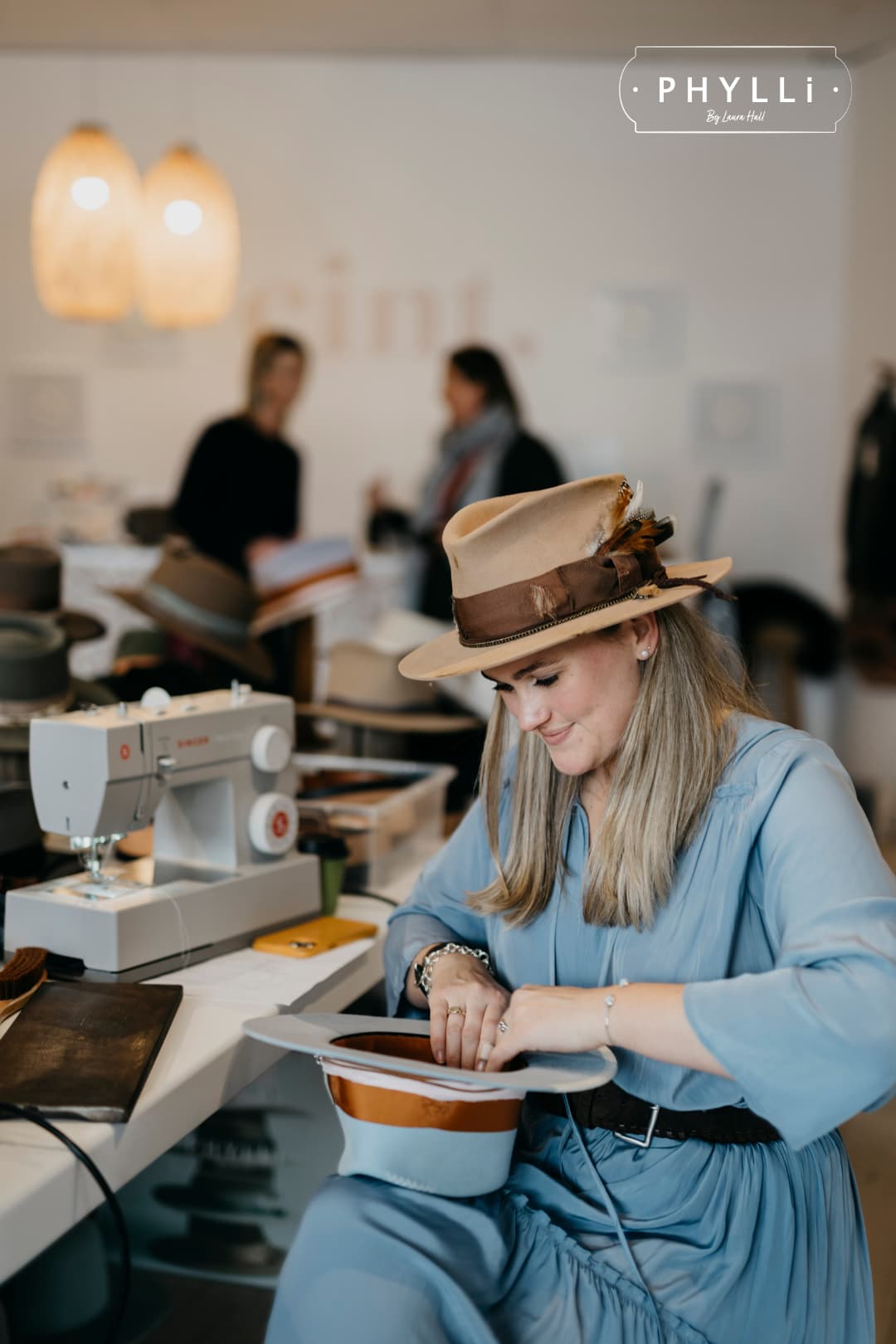 Laura Hall, founder of PHYLLi Designs, wearing the Roadie camel felt hat while working in the studio.