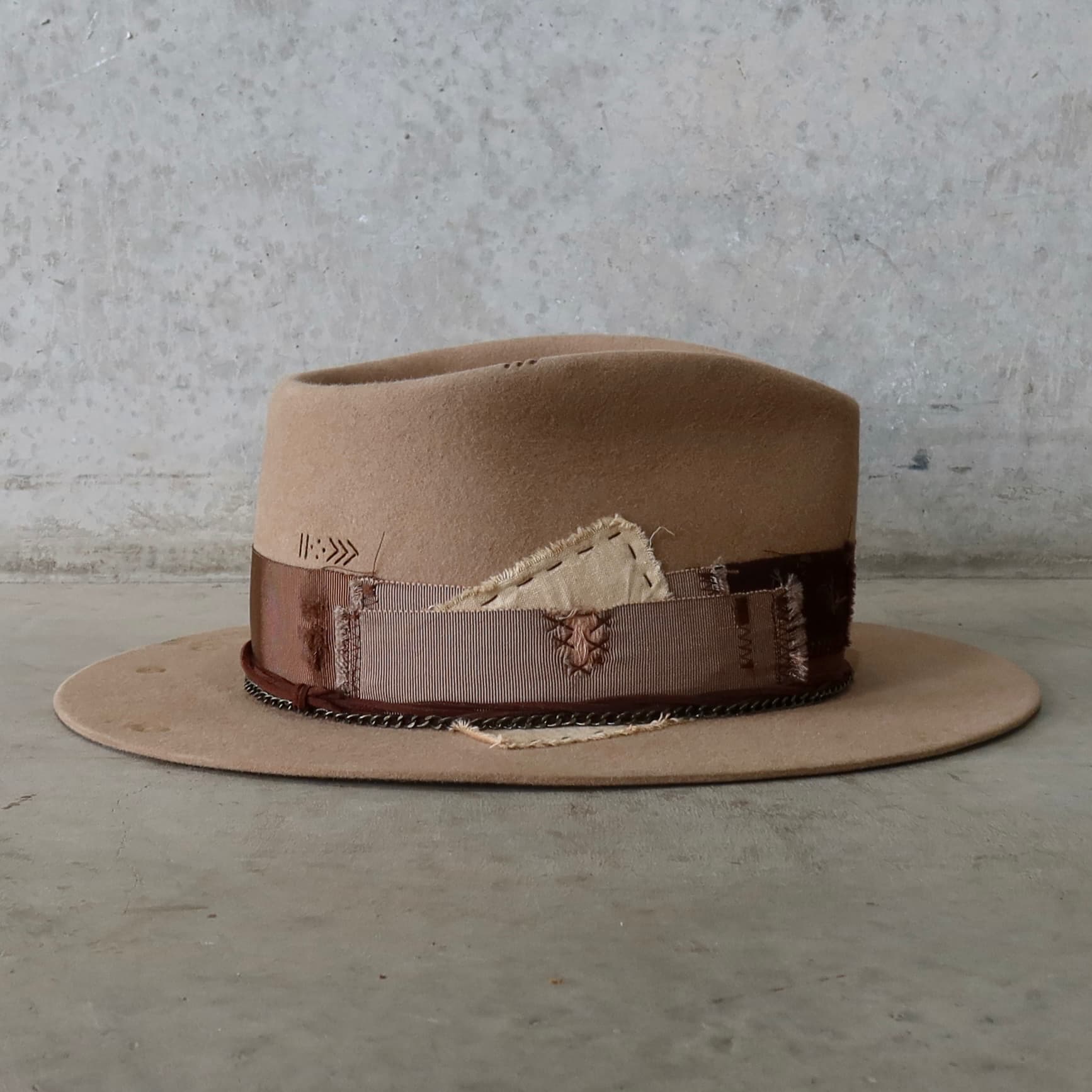 Right side view of Roadie felt hat by PHYLLi Designs with distressed grosgrain band and worn linen patch detailing.