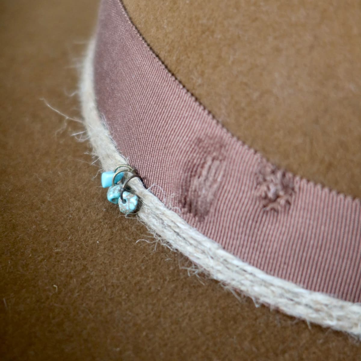 Close up detail of the Rue cowboy hat showing turquoise bead detail on the twine wraps.