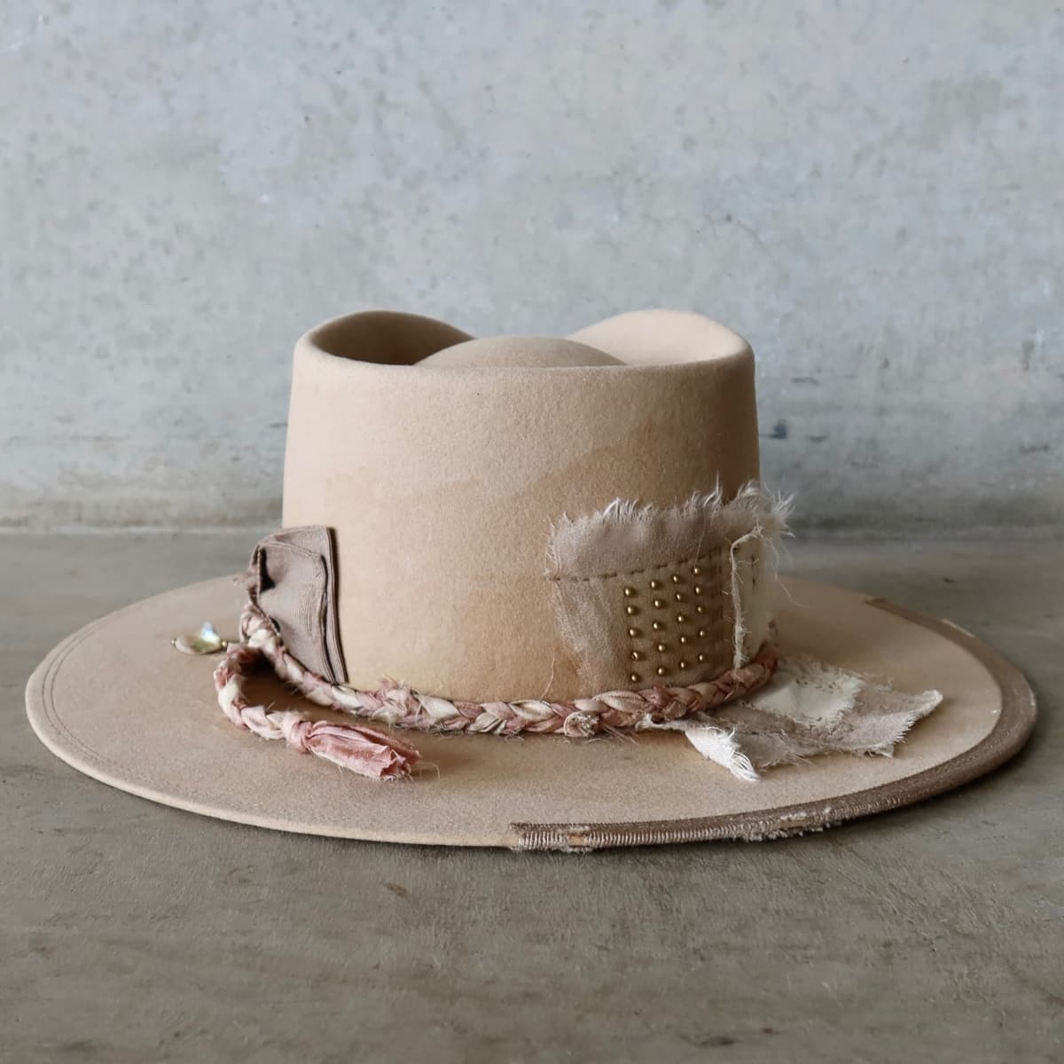 Back view of the sand distressed felt hat Ryoan Limited Edition by PHYLLi Designs featuring Wabi Sabi linen and silk patches with gold beading.