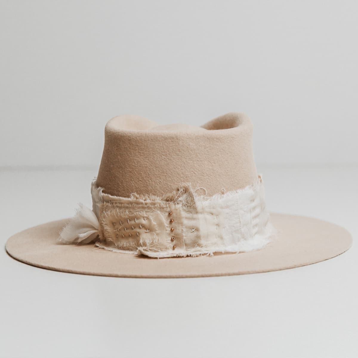 Back view of the Sabi Limited Edition Beige felt hat by PHYLLi Designs featuring Wabi Sabi patch band with scattered matte gold beading.