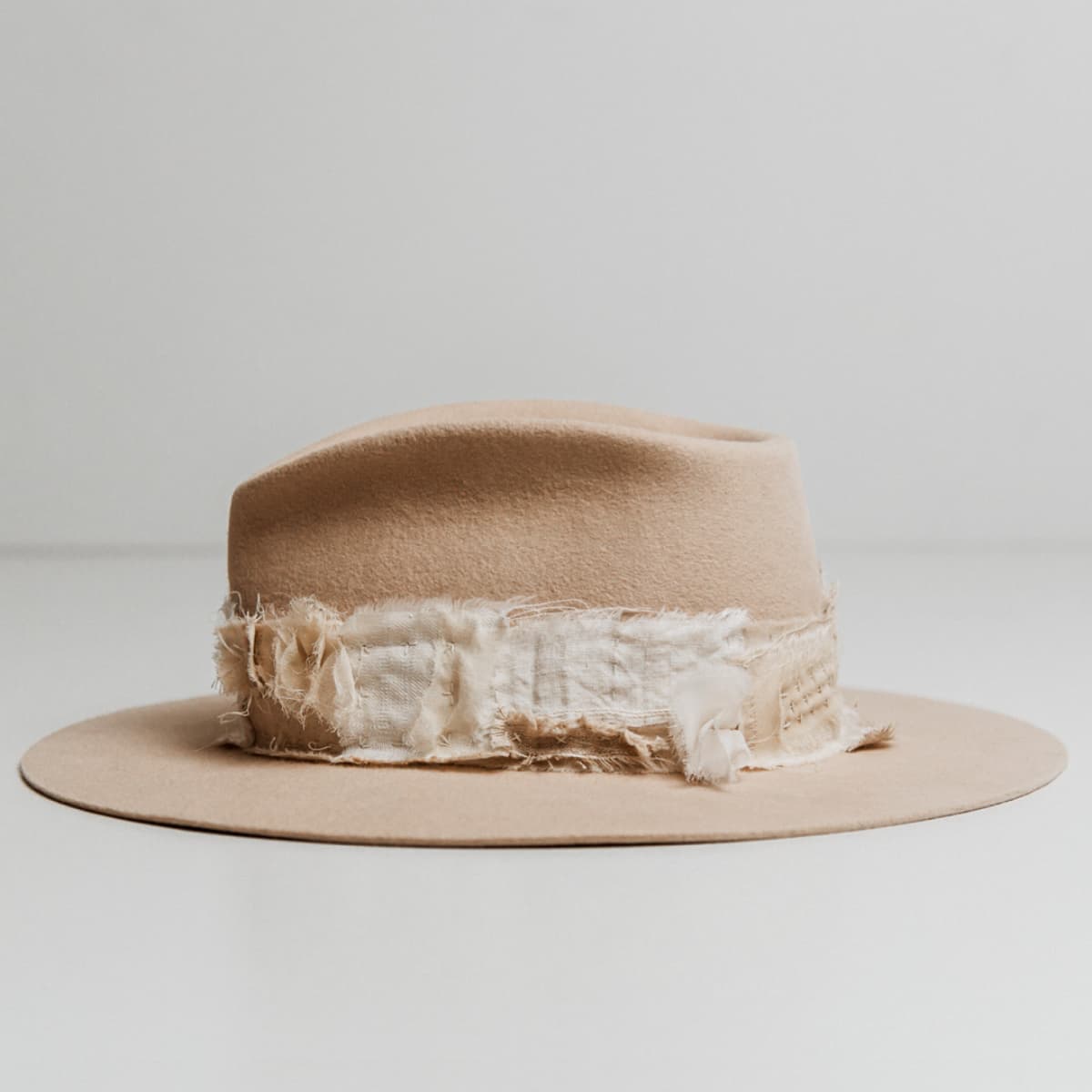 Left side view of the Sabi Limited Edition Beige felt hat by PHYLLi Designs with sashiko stitched patch band and matte gold bead accents.