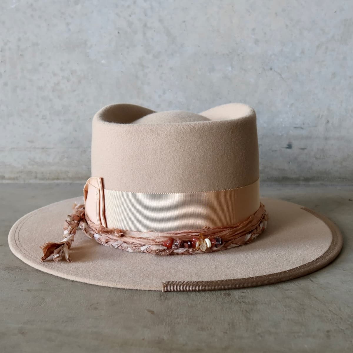 Back view of the sand felt hat Sandstone Limited Edition by PHYLLi Designs featuring apricot Japanese grosgrain double bow band.