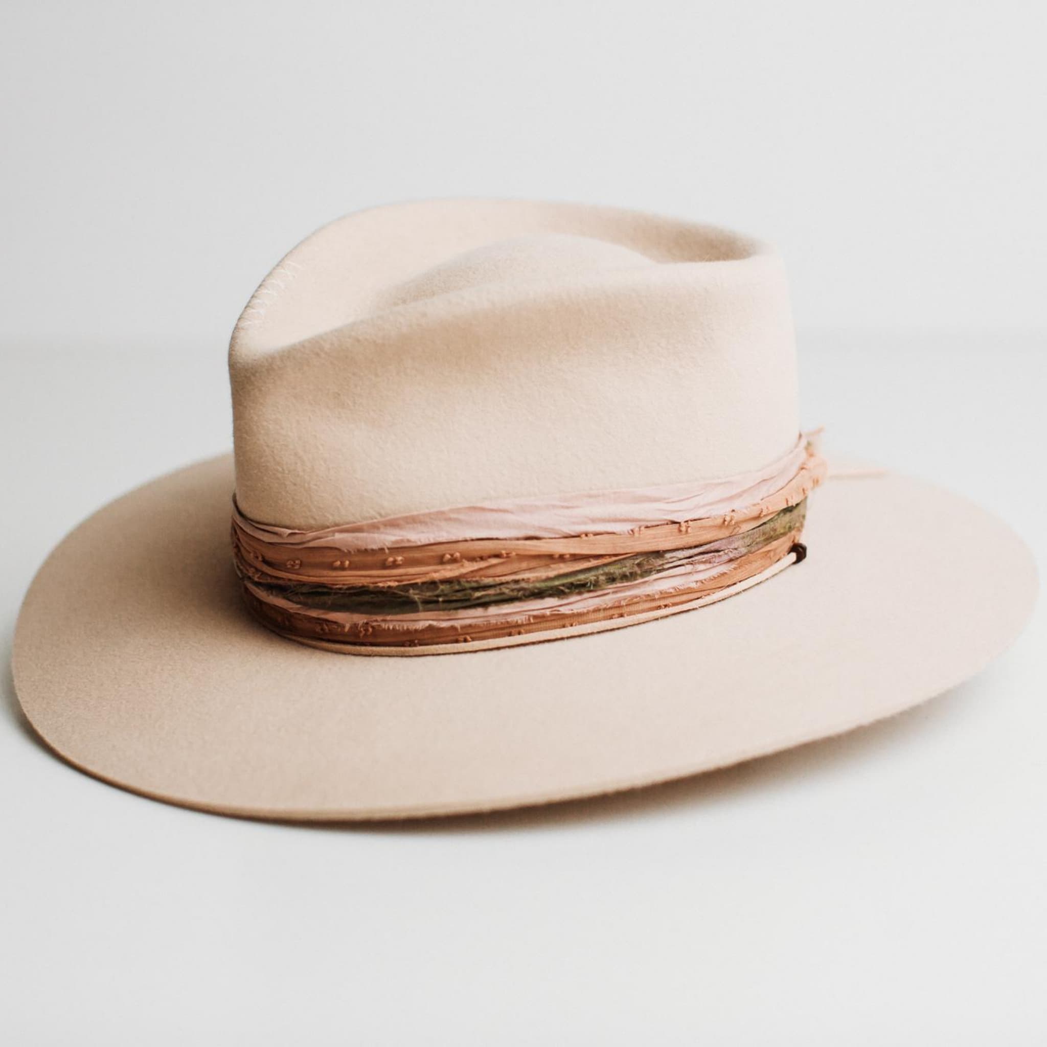 Front left angle of Santa Fe Summer beige felt hat by PHYLLi Designs featuring plaster grosgrain band and sari silk trim.