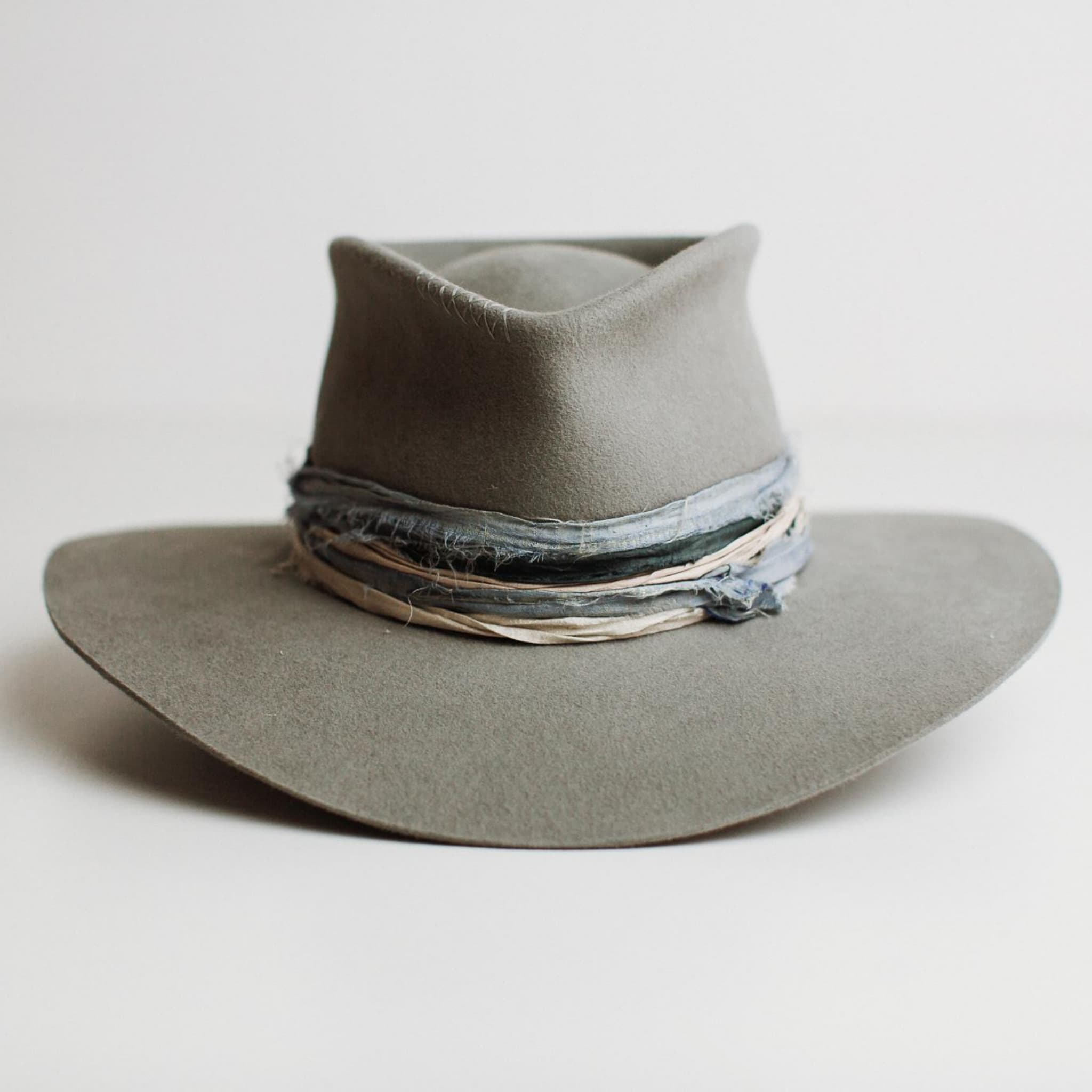 Front view of Santa Fe Winter felt hat by PHYLLi Designs with cement Japanese grosgrain band and sari silk trim in teal, storm blue and smoke.