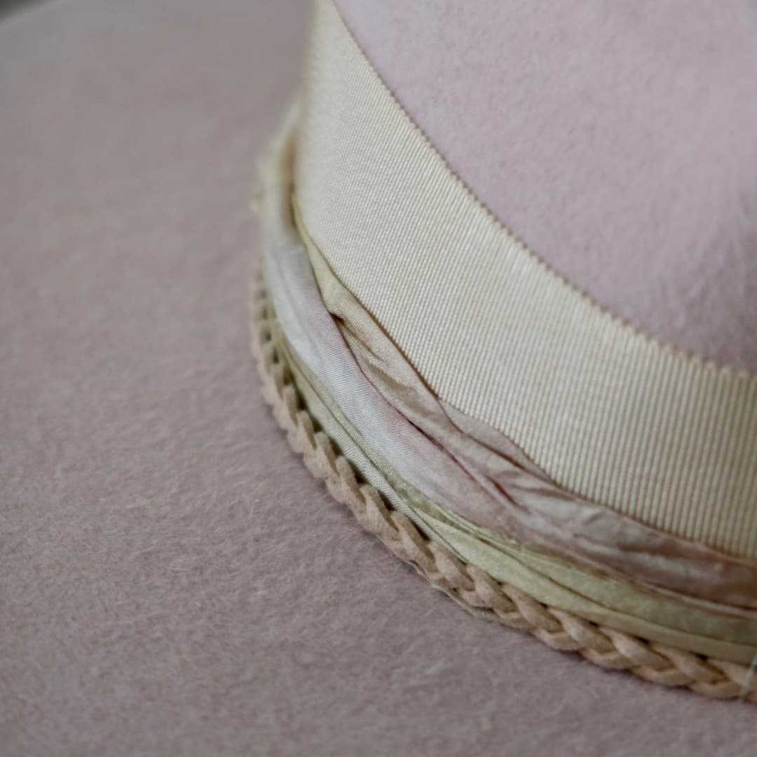 Close up detail of the Sorbet felt hat showing plaited nude suede string with rough pearl pendant charm.