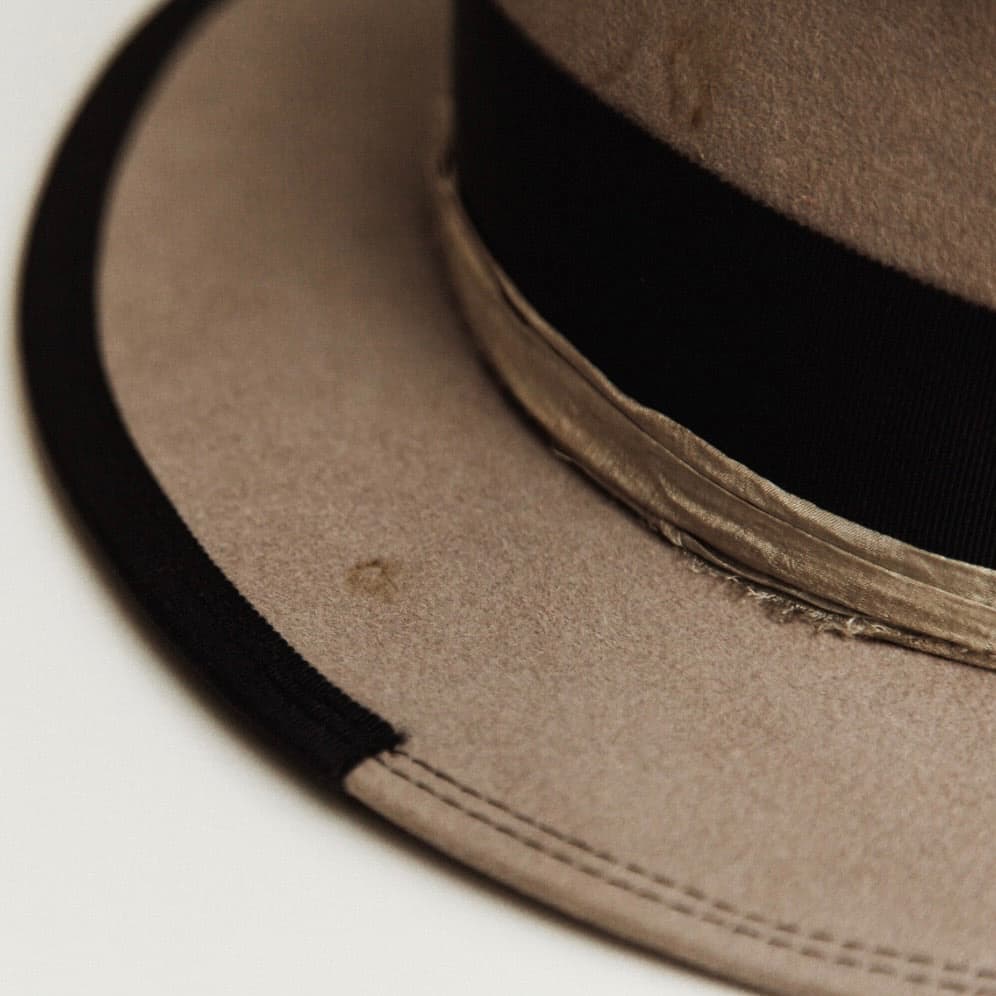 Close up detail of the Specter felt hat showing dark navy double brim stitch and distressed taupe rabbit felt.
