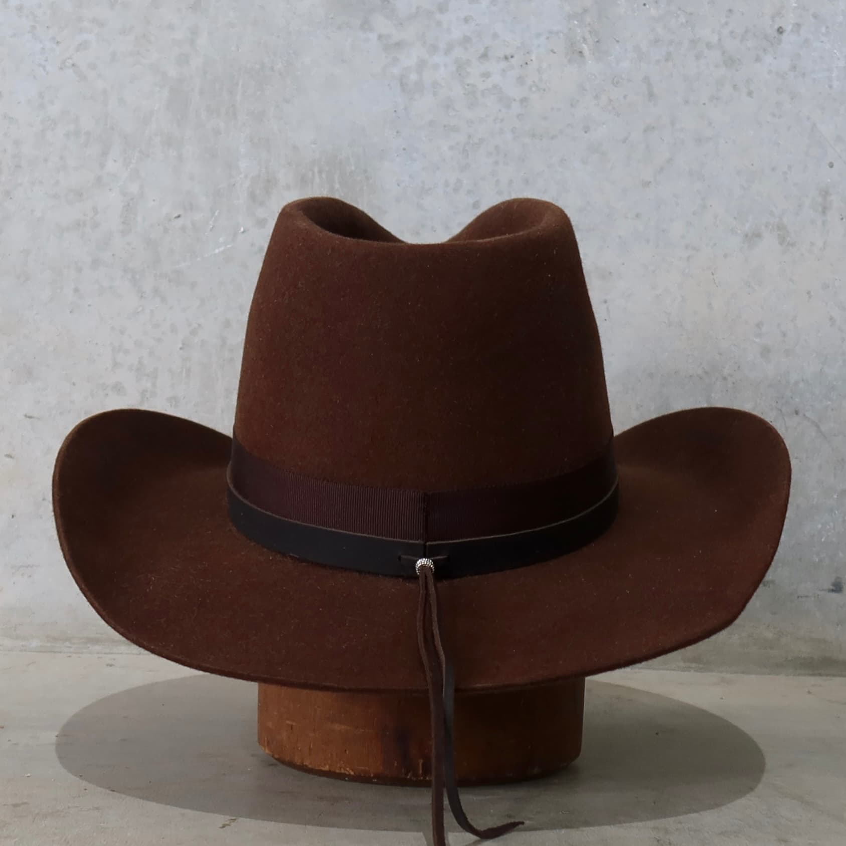 Back view of the chocolate cowboy hat Spicer by PHYLLi Designs featuring dark brown leather tie back detail.