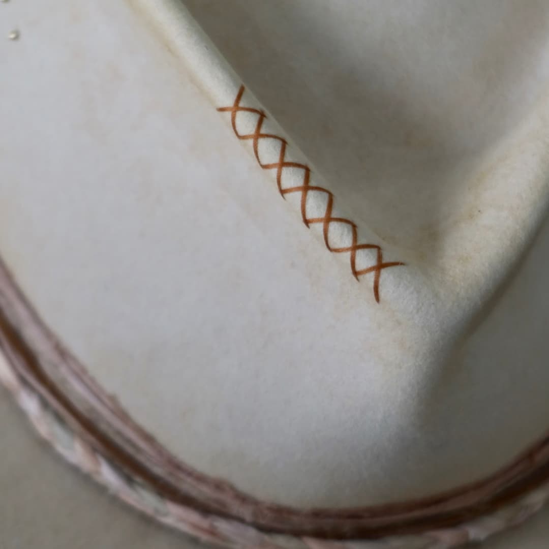 Close up detail of the Starlight felt hat showing the copper hand stitched crosses on the crown.