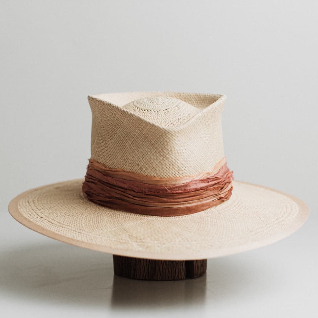 Front view of the Sunset Panama natural Panama hat by PHYLLi Designs with sand Japanese grosgrain band and layered sari silk trimming.